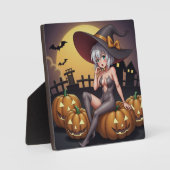 緑の目をしたハロウィンの魔女が、ジャック・オ・ランタンの上に フォトプラーク (正面)