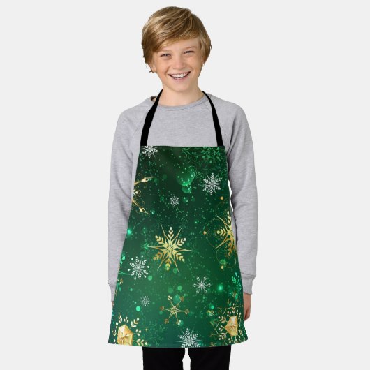 緑の背景に金のクリスマスの雪の結晶 エプロン (着用した状態)
