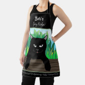 緑の草が生い茂ったフェンスの上の黒猫 エプロン (インサイチュ)