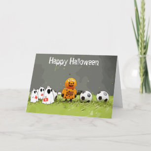 緑の草の上にボールを持つサッカーハッピーハローウィン カード