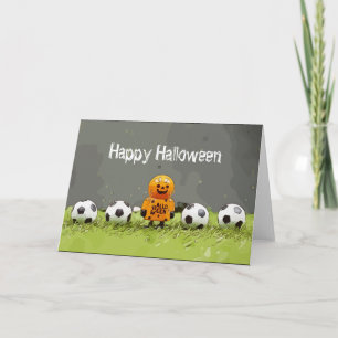 緑の草の上にボールを持つサッカーハッピーハローウィン カード