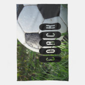 緑の草の中の白と黒のサッカーボール キッチンタオル (縦)