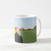 緑の草原に立つ黒いコートを着た女性  コーヒーマグカップ (正面右)