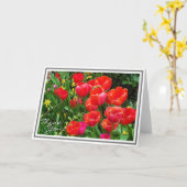 緑の葉に対する明るい赤いチューリップ カード (黄色い花)