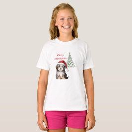 背景にクリスマスツリーがある犬 Tシャツ