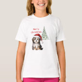 背景にクリスマスツリーがある犬 Tシャツ (正面)