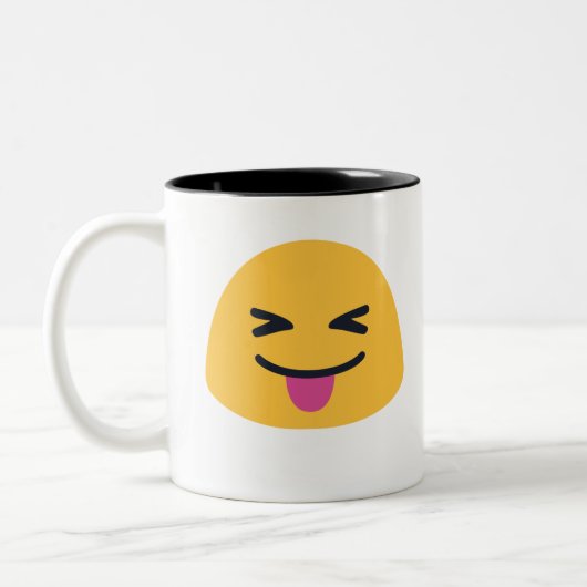 舌を閉じた目を突き出す絵文字 ツートーンマグカップ (左)