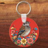 花とフレームに囲まれた枝上のカラフルな鳥 キーホルダー (裏面)