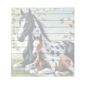 花の咲く木々の間で休む馬と馬 ノートパッド (正面)