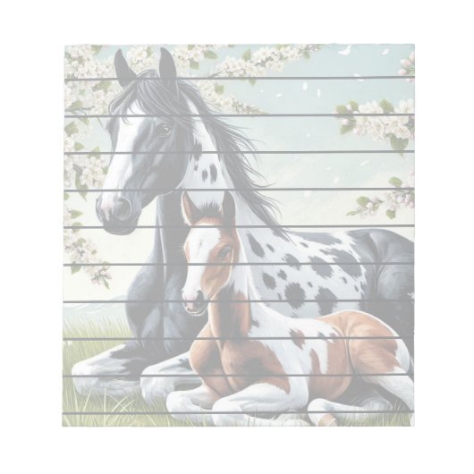 花の咲く木々の間で休む馬と馬 ノートパッド (正面)