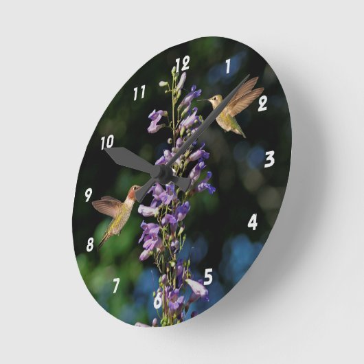 花の壁の時計を持って飛んでいる二羽のハチドリ ラウンド壁時計 (傾斜)
