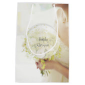 花の花束を持つ美しい結婚花嫁 ミディアムペーパーバッグ (裏面)