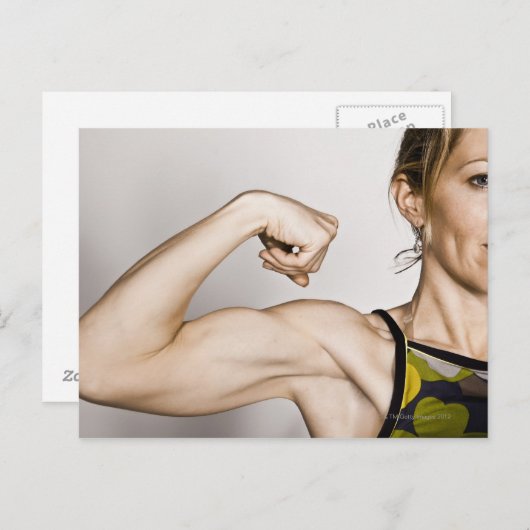 若いブロンドの女性は二頭筋を曲げる一方 ポストカード (正面/裏面)