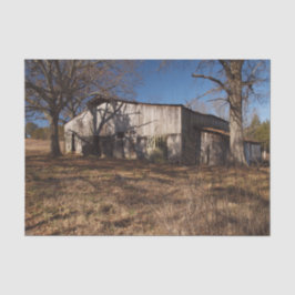 茶色い草の中の老朽化した薄茶色の納屋 薄葉紙