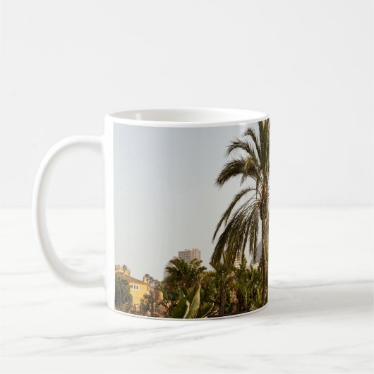 茶色のコンクリート建物の近くの緑のヤシ コーヒーマグカップ (左)