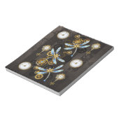 茶色の背景にスチームパンクストライプのトンボ ノートパッド (回転)