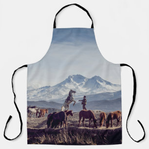 茶色の野原で昼に山を見る馬 エプロン