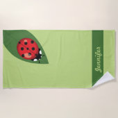葉っぱに描かれた可愛らしい漫画のラディバグと名前をカスタムする ビーチタオル (正面)