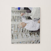 薬剤師が薬を計数機に注ぎ込む ジグソーパズル (縦)