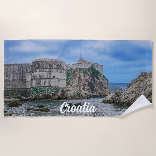 要塞の壁、岩の多い海岸、クロアチアの海 ビーチタオル (正面)