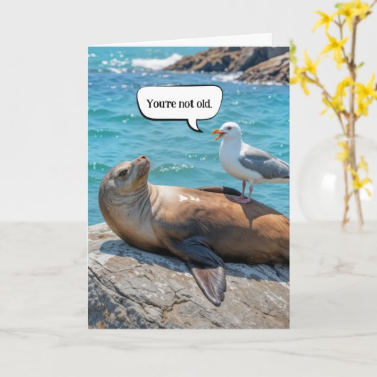 誕生日のユーモアカモメがアシカに止まる カード (黄色い花)