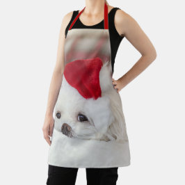 赤いクリスマスの帽子をかぶったかわいい白犬 エプロン