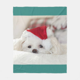 赤いクリスマスの帽子をかぶったかわいい白犬 フリースブランケット