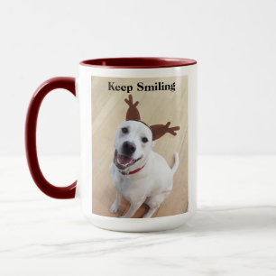 赤いクリスマスを祝う微笑みを浮かべる白犬 マグカップ