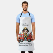 赤いトラックに乗って喜ぶ若い消防士 エプロン (着用した状態)