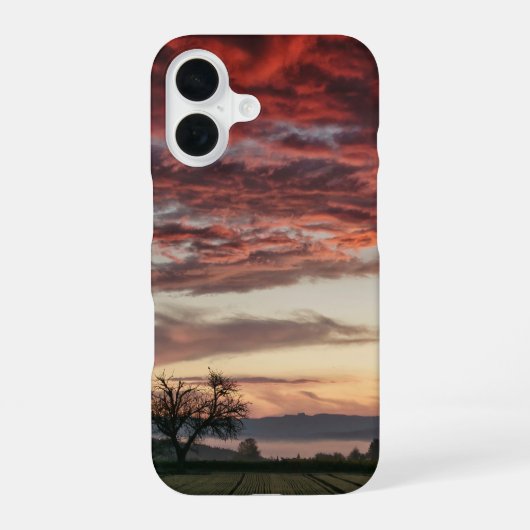 赤い雲の夕焼けの木 緑の野原 iPhone 16ケース (裏面)