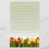 赤く黄色いチューリップによっては並ぶ緑の背景が開花します 便箋 (正面)