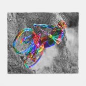 道の下で競争しているテクニカラー山のバイクもしくは自転車に乗る人 フリースブランケット (正面(横))