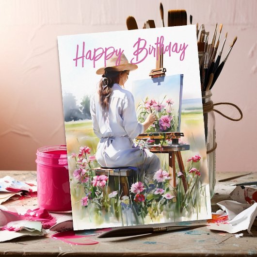 野原で花を描く女性アーティストの誕生日 カード