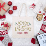 金ゴールドモダンスクリプトメリークリスマス名前をカスタムする トートバッグ<br><div class="desc">メリースタイリッシュクリスマスのトートバッグのデザインは、ホリーの葉フェスティバルの緑の枝と赤い果実がアンティークの金ゴールドのスクリプトのデザインにアクセントモダンを特徴とする。モノグラカスタムム文字は名パーソナライズされた前または他の文字である。</div>