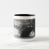 雪で覆われた川上の石造り橋 ツートーンマグカップ (中央)