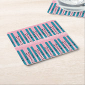 雪とピンクの背景の青いスキー スクエアペーパーコースター (アングル)