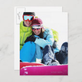 雪に坐るスノーボーダーのカップル ポストカード (正面/裏面)