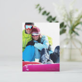 雪に坐るスノーボーダーのカップル ポストカード (スタンド正面)
