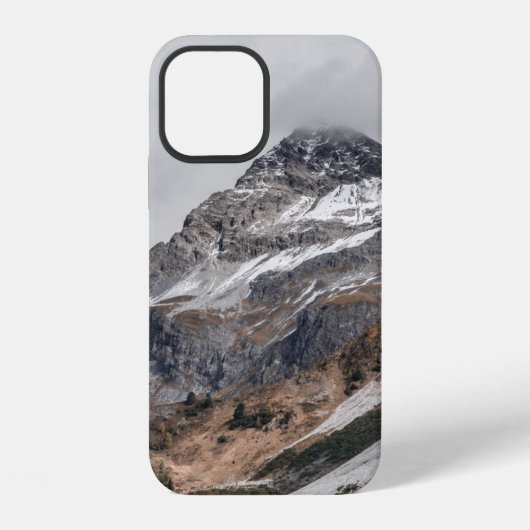 雪に覆われた灰色の山々が木々に囲まれて iPhoneケース (裏面)