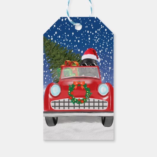 雪のクリスマスに車を運転するニューファンドランド犬 ギフトタグ (裏面)