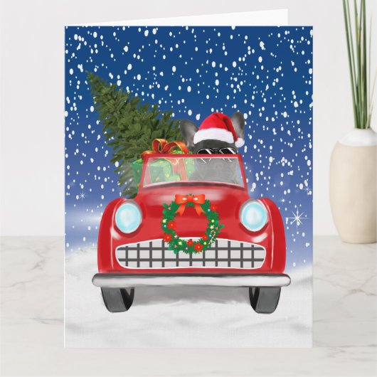 雪のクリスマスに車を運転するフレンチブルドッグ カード (正面)