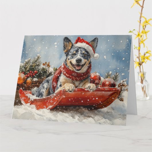 雪のクリスマスを許すそりの青いヒーラー犬 カード (黄色い花)