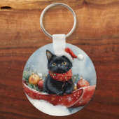 雪のクリスマスを過ごすソリの黒猫 キーホルダー (正面)