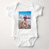 雪のクリスマスハットに座って可愛い大きなデーン犬 ベビーボディスーツ (正面)