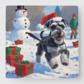 雪のクリスマス帽子をかぶったシュナウザー スクエア壁時計 (正面)