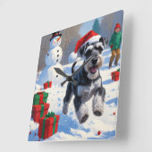 雪のクリスマス帽子をかぶったシュナウザー スクエア壁時計 (傾斜)