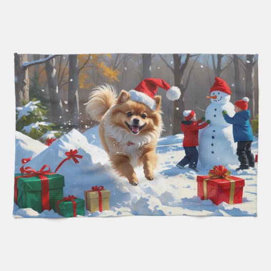 雪のクリスマス帽子をかぶったポメラニアンが走る キッチンタオル (横)