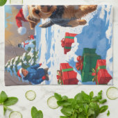 雪のクリスマス帽子を被ったスカイテリアが走る キッチンタオル (折り畳み)