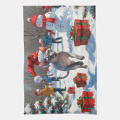 雪のクリスマス帽子を被ったスフィンクス猫が走る キッチンタオル (縦)