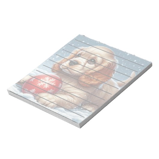 雪の上でボールで休むコッカースパニエル犬の子犬 ノートパッド (回転)